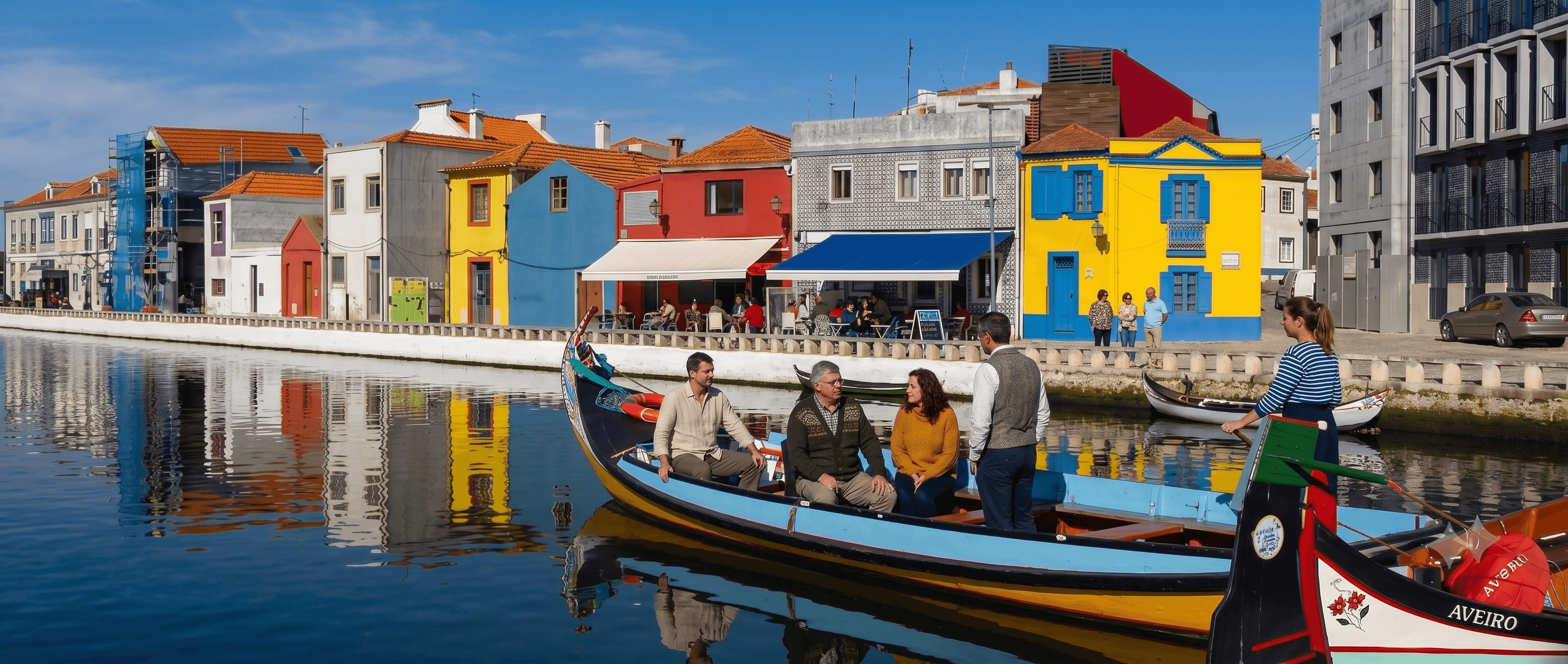 Moliceiro boats on the canal network in Aveiro, with the city's Art Nouveau facades visible along the waterfront