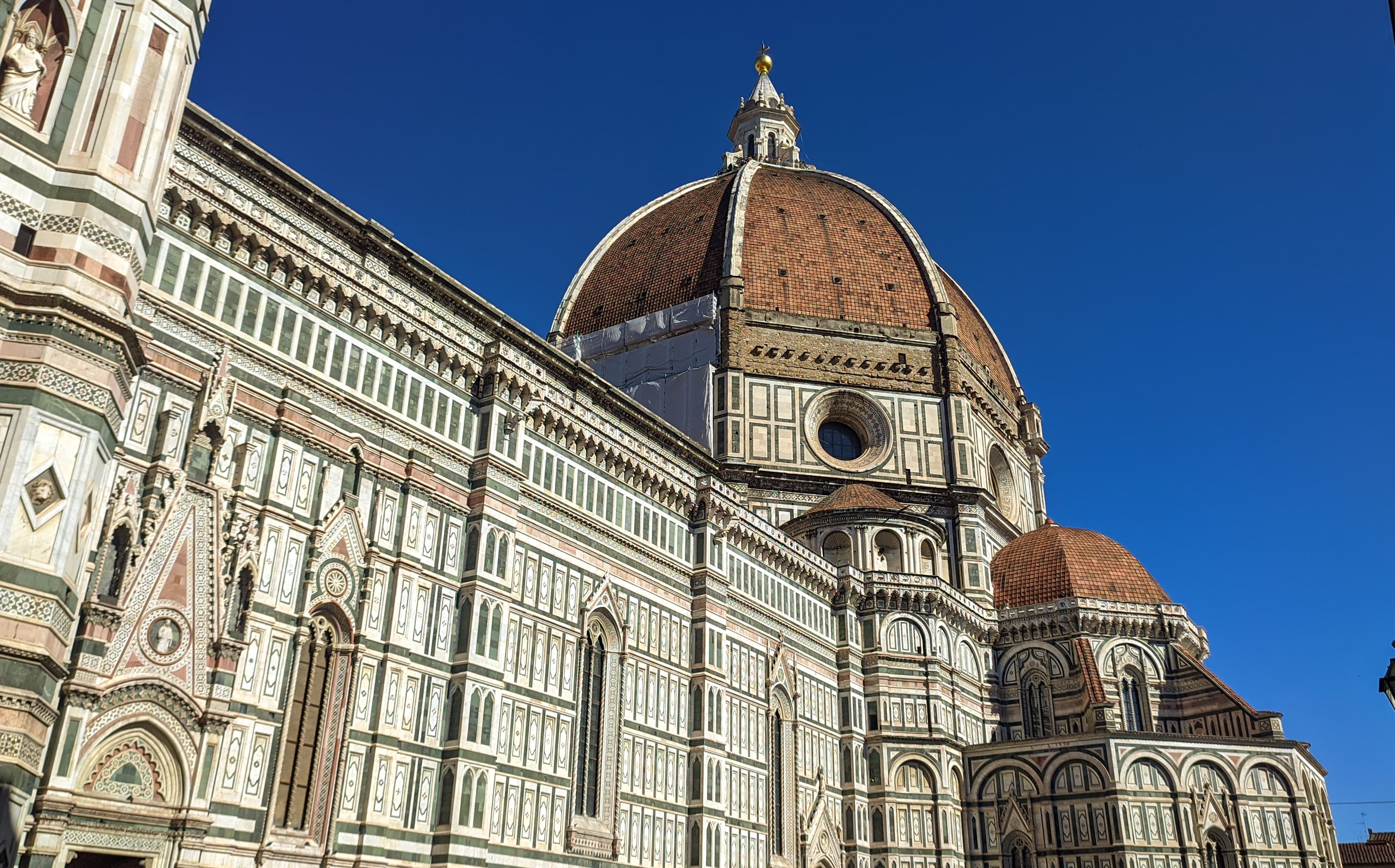 The Florence Duomo and Campanile rising above the terracotta rooftops of the historic centre, seen from Piazzale Michelangelo